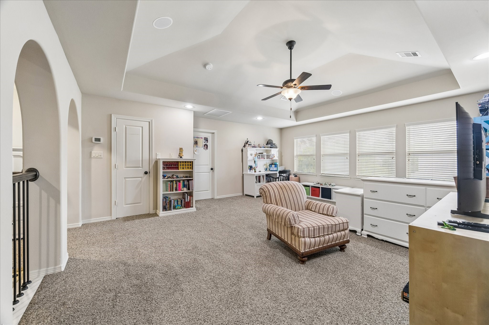 3 Tiburon Court Spring, TX 77389 - Photo 20 of 37 Gameroom features a row of large windows providing ample natural light. It boasts a ceiling fan and recessed lighting, making it ideal for a family or game room.