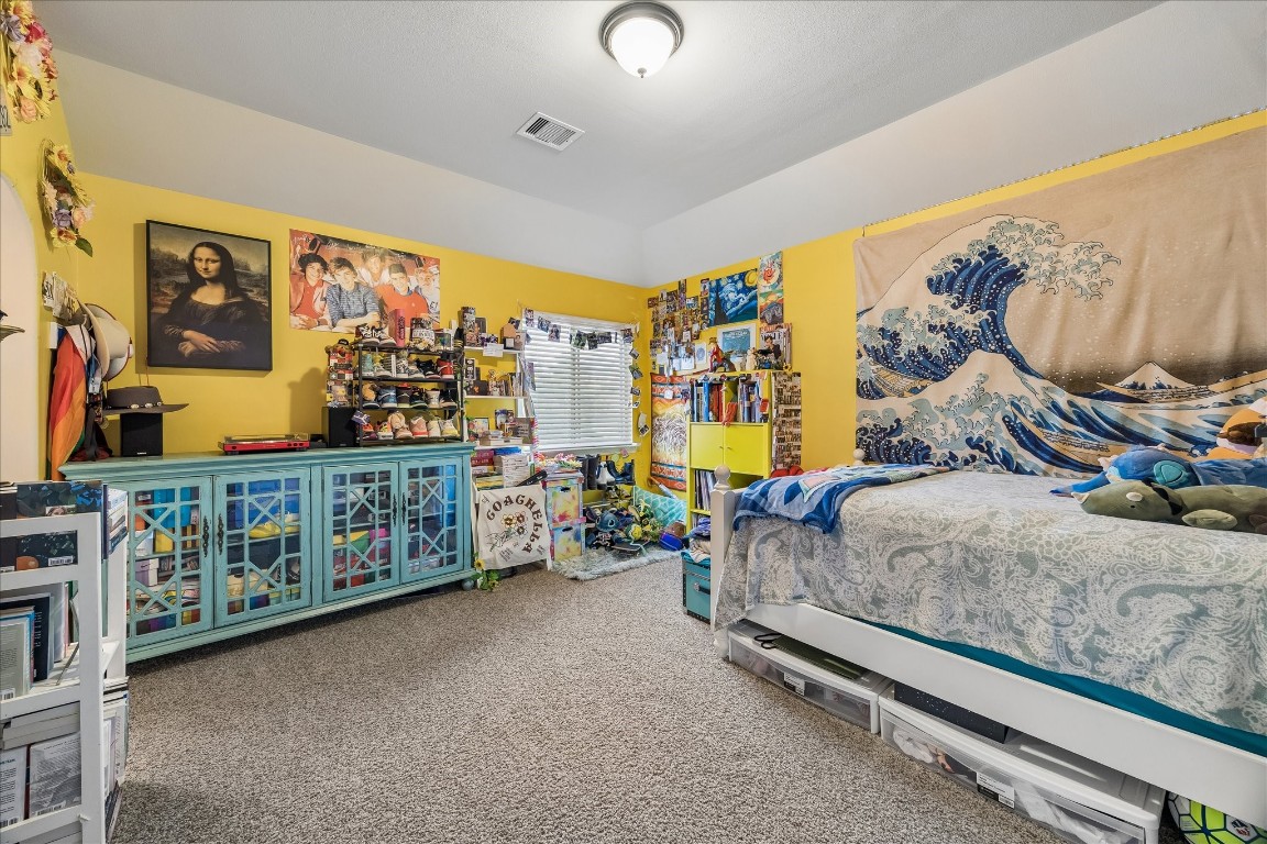 3 Tiburon Court Spring, TX 77389 - Photo 23 of 35 This cozy bedroom features bright yellow walls and a vaulted ceiling, creating a cheerful atmosphere.