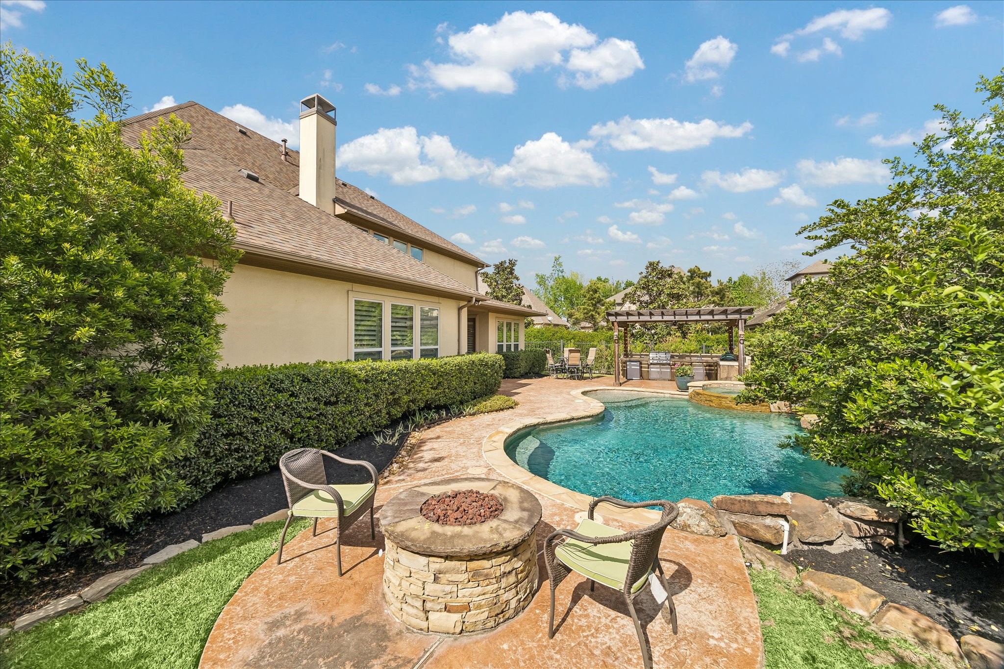 3 Tiburon Court Spring, TX 77389 - Photo 30 of 37 There's a cozy seating area with a fire pit on a stone patio, perfect for outdoor relaxation.