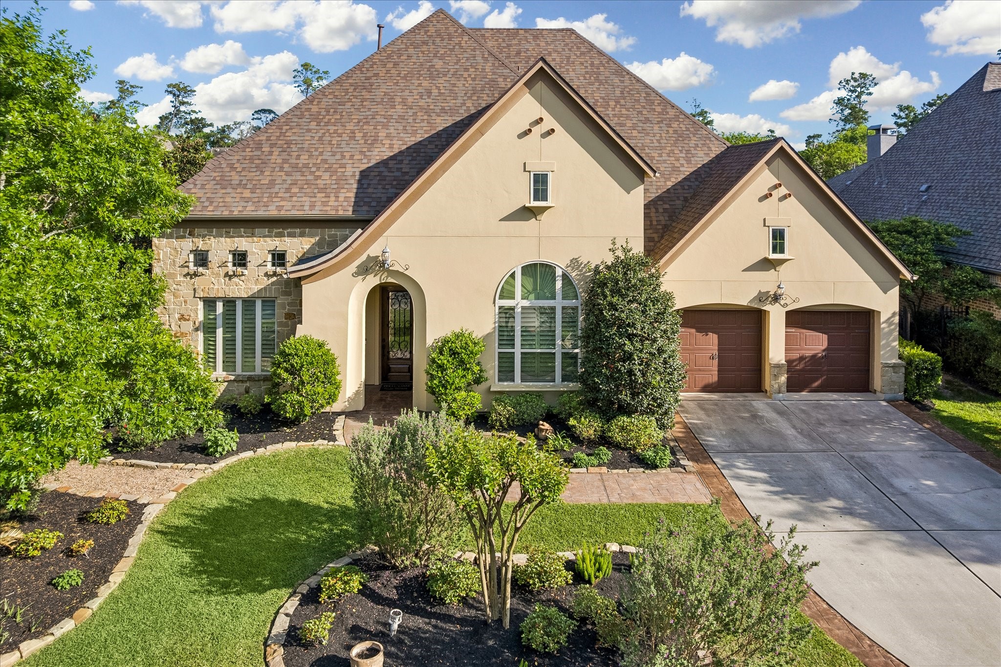 3 Tiburon Court Spring, TX 77389 - Photo 32 of 37 This charming home features a beautiful stone and stucco exterior with a pitched roof and arched windows. The well-maintained front yard includes lush landscaping, while the driveway leads to a two-car garage. Ideal for buyers seeking a picturesque and inviting residence.