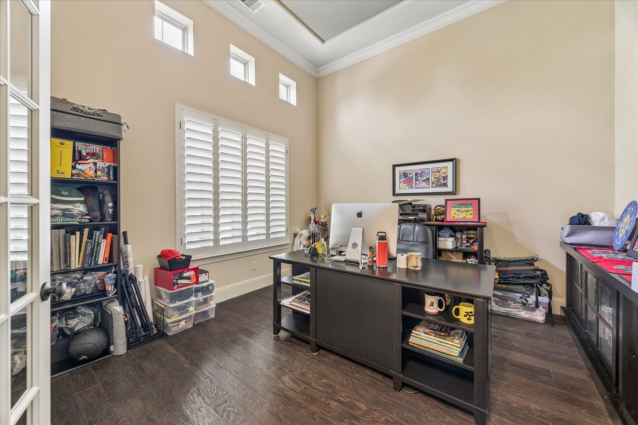 3 Tiburon Court Spring, TX 77389 - Photo 6 of 37 Home office with high ceilings, abundant natural light through multiple windows, and elegant plantation shutters. The room features dark wood flooring and French doors, creating a functional and stylish workspace.