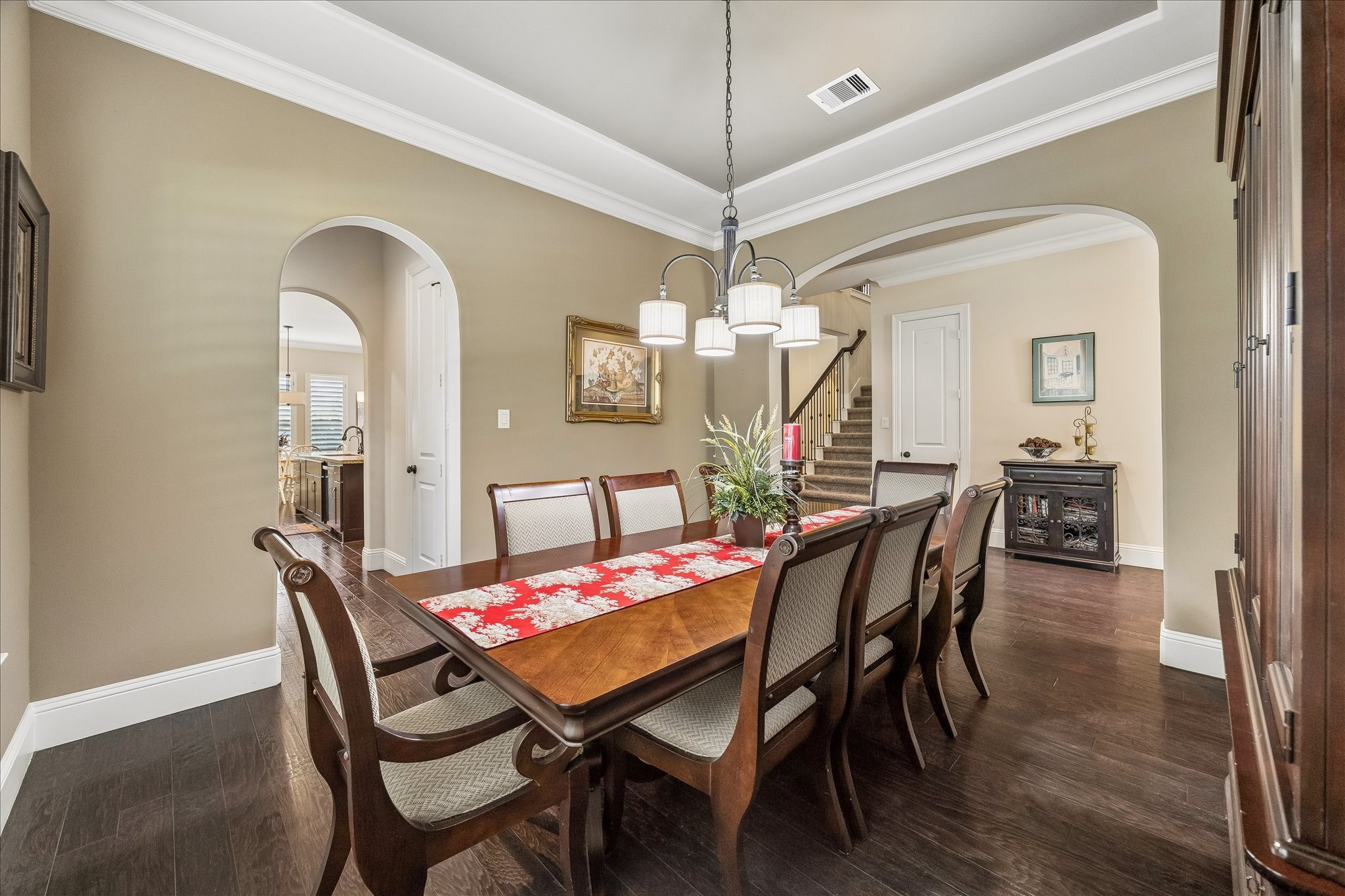 3 Tiburon Court Spring, TX 77389 - Photo 8 of 37 This is a stylish dining room featuring warm, neutral walls, elegant crown molding, and a modern chandelier.