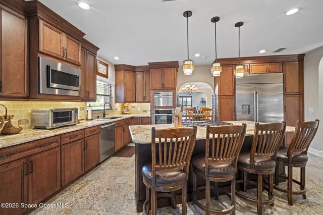 a dining room with furniture a chandelier and wooden floor