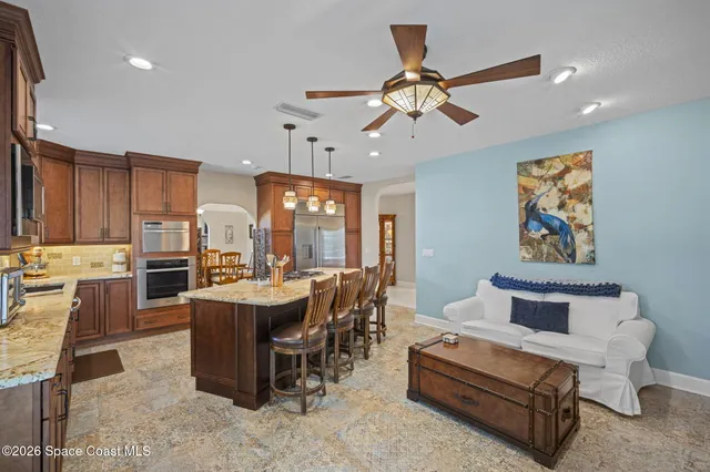 a living room with couches a dining table and chairs with wooden floor