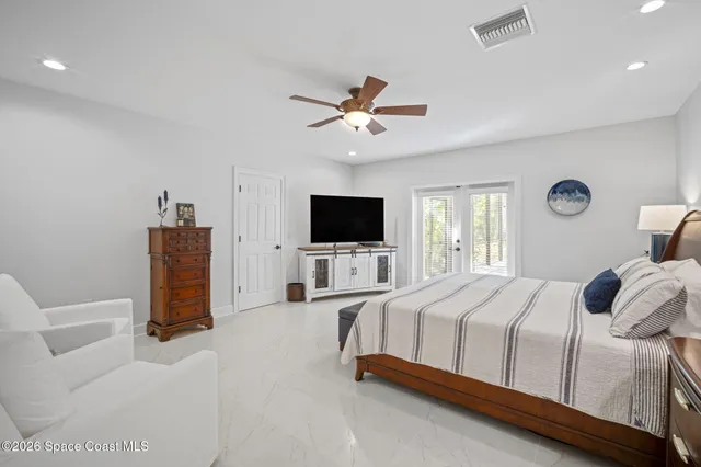 a bedroom with a bed a flat screen tv and a couch