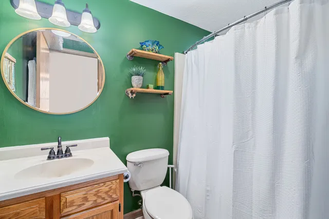 a bathroom with a sink mirror and toilet