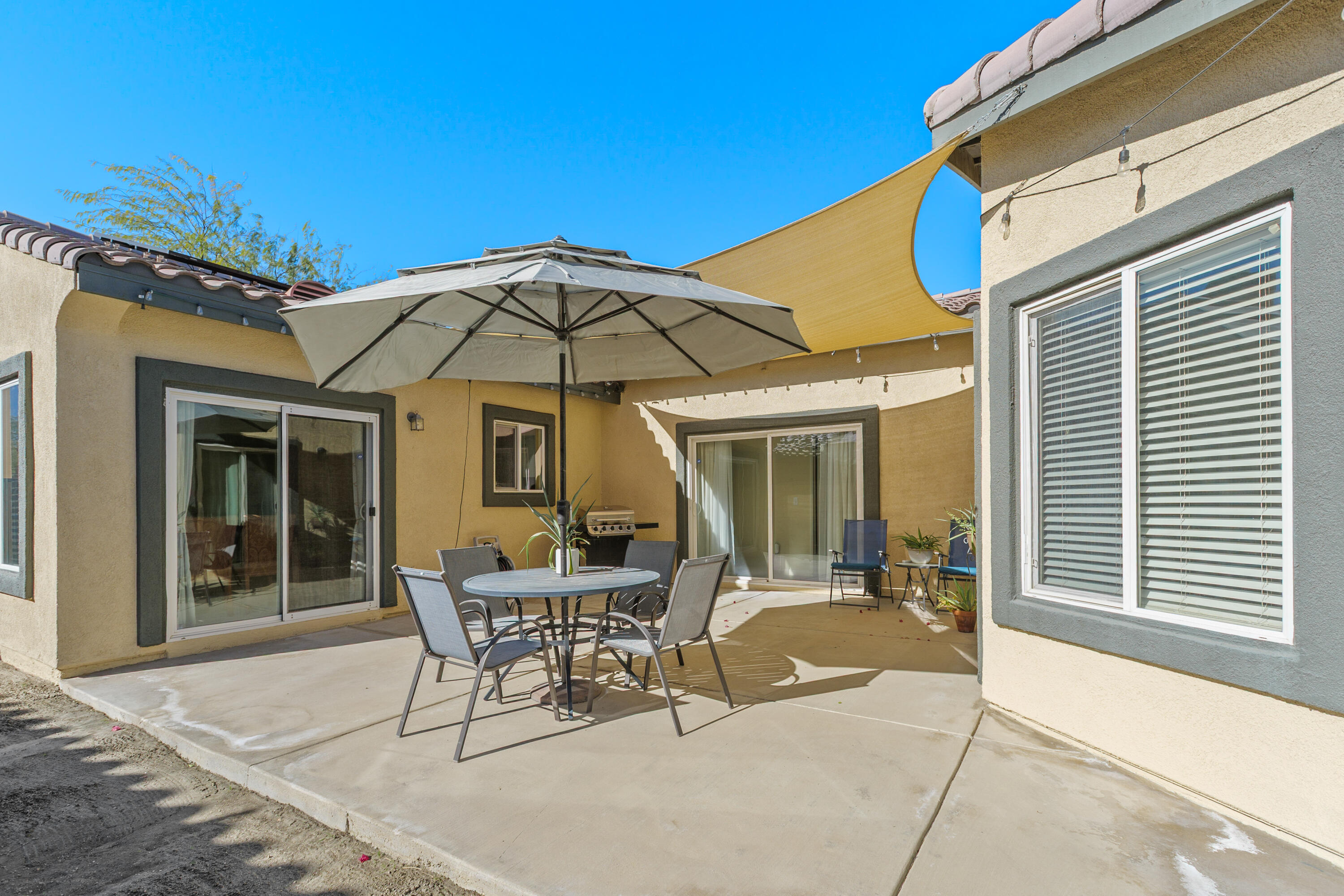 26700 Rio Dulce Road Cathedral City, CA 92234 - Photo 19 of 20 a patio with a table and chairs under an umbrella