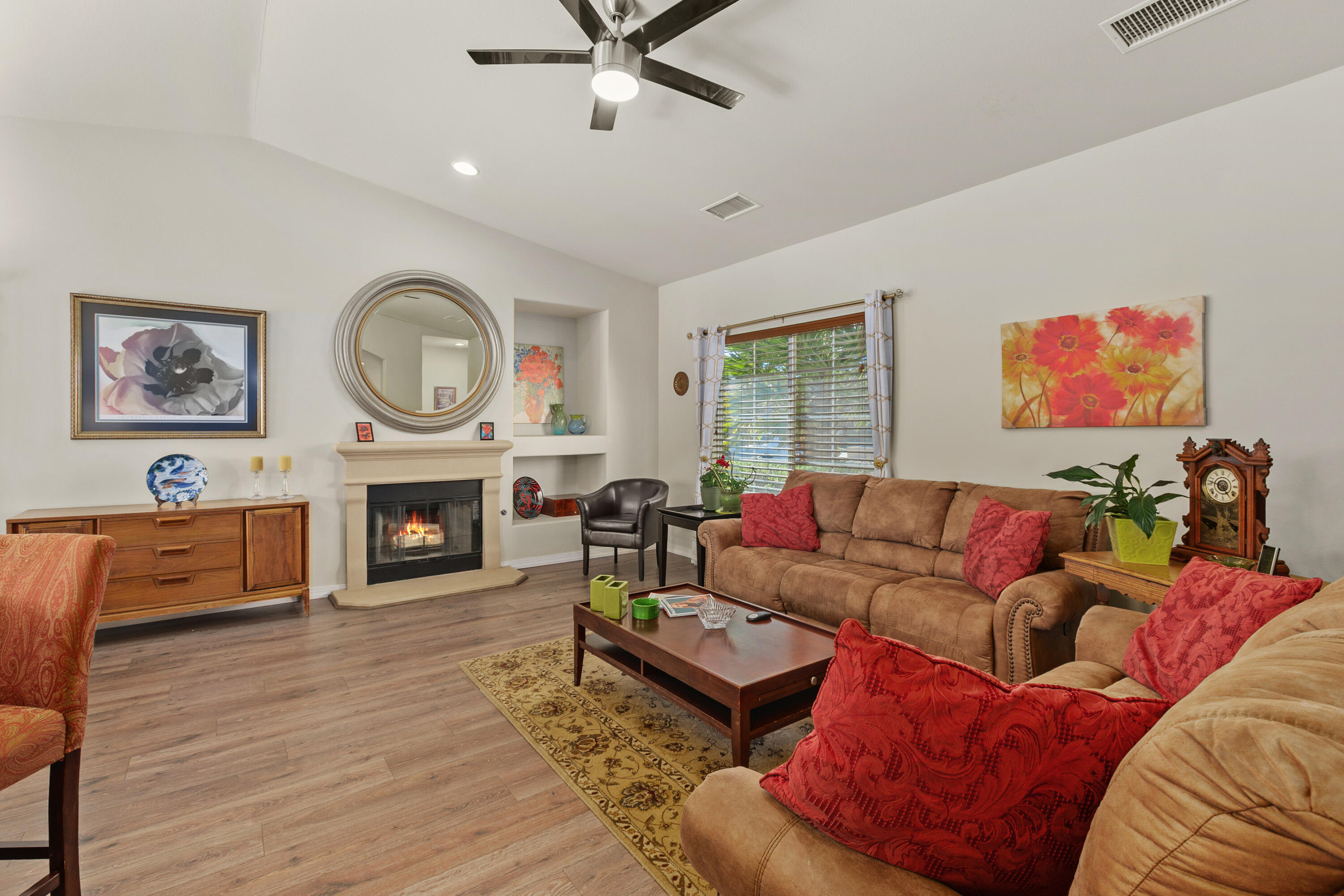 26700 Rio Dulce Road Cathedral City, CA 92234 - Photo 4 of 20 a living room with furniture a clock and a fireplace