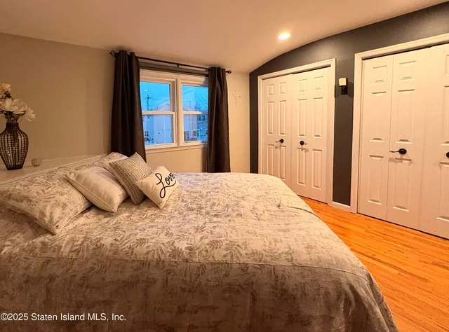 a large bedroom with a bed and wooden floor