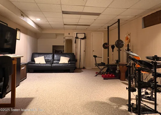 a bedroom with furniture a flat screen tv and gym equipment