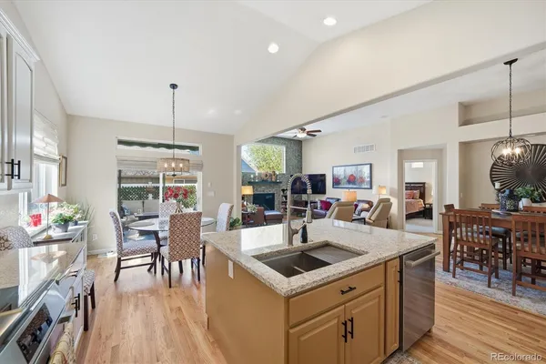 a view of a dining room and livingroom with furniture wooden floor a chandelier