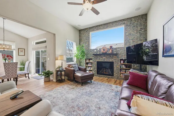 a living room with furniture a large window and a fireplace