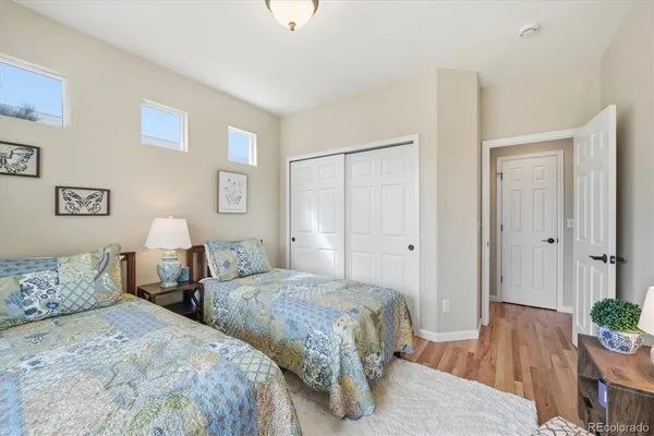 a bedroom with two bed and a potted plant