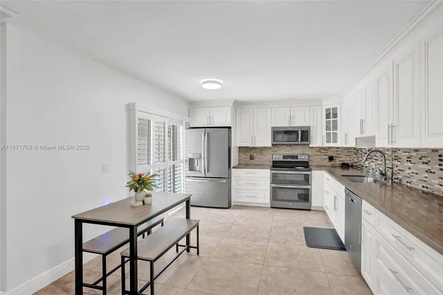 a kitchen with refrigerator a stove and chairs
