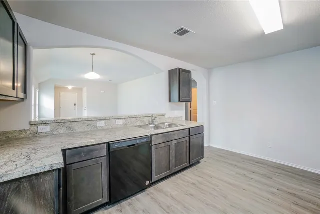 a view with granite countertop kitchen island a sink appliances and a counter space