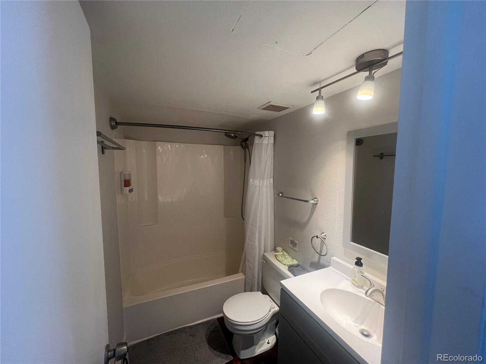 9876 Ryan Gulch Road, Unit 104 Silverthorne, CO 80498 - Photo 11 of 15 a bathroom with a granite countertop sink toilet and shower