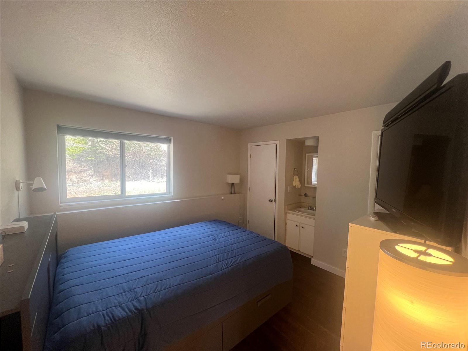 9876 Ryan Gulch Road, Unit 104 Silverthorne, CO 80498 - Photo 12 of 15 a bedroom with a bed and a window