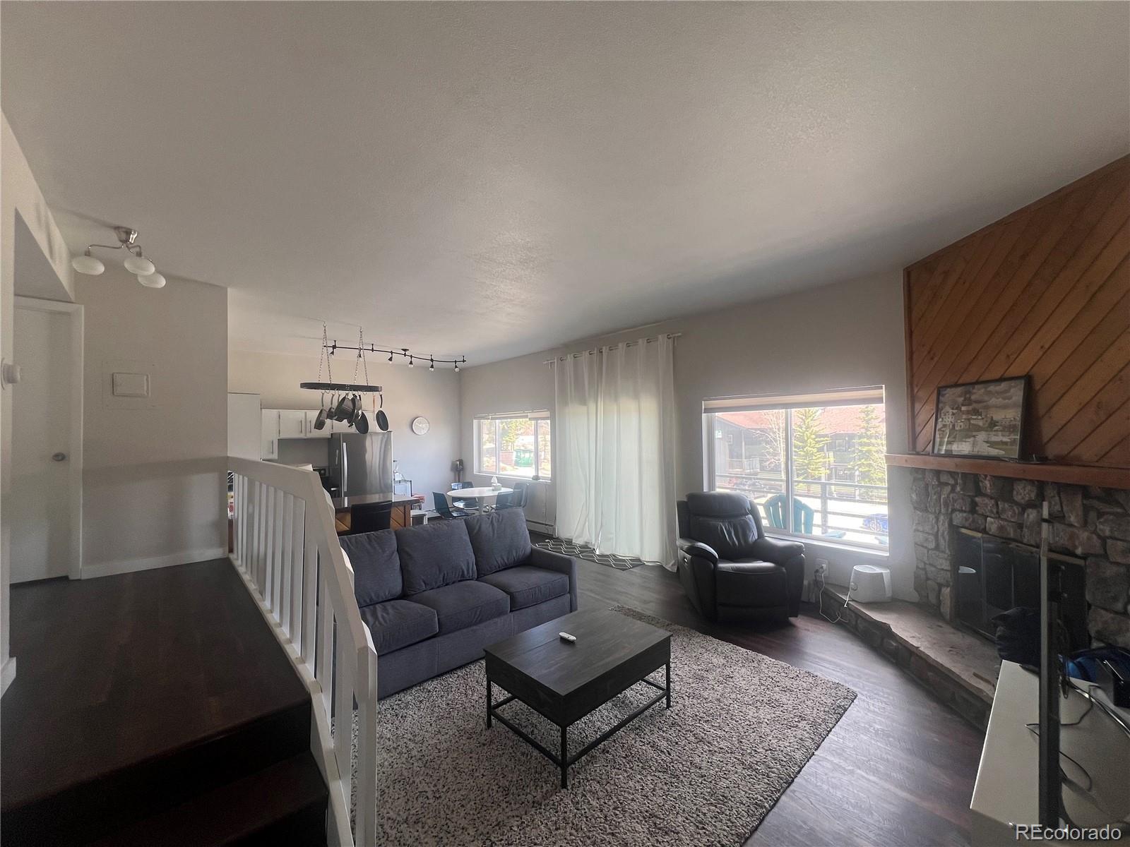 9876 Ryan Gulch Road, Unit 104 Silverthorne, CO 80498 - Photo 4 of 15 a living room with furniture a fireplace and a window