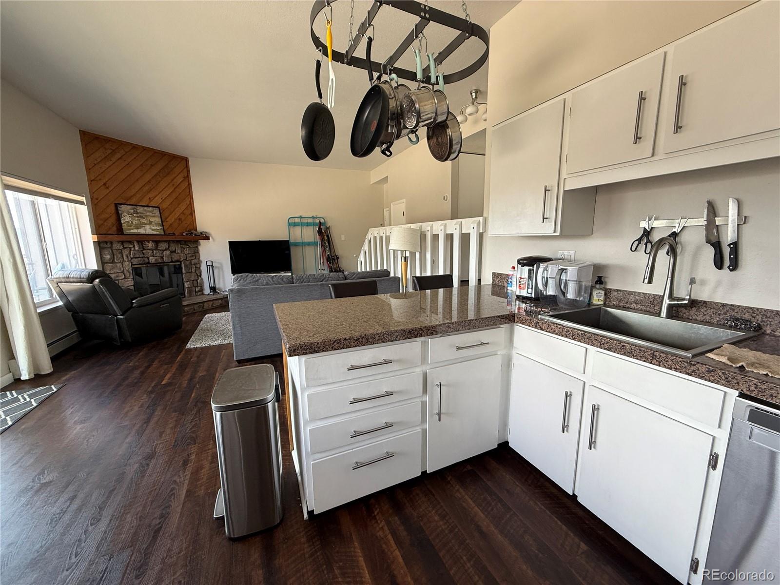 9876 Ryan Gulch Road, Unit 104 Silverthorne, CO 80498 - Photo 5 of 15 a kitchen with stainless steel appliances granite countertop a white cabinets a stove and a wooden floors