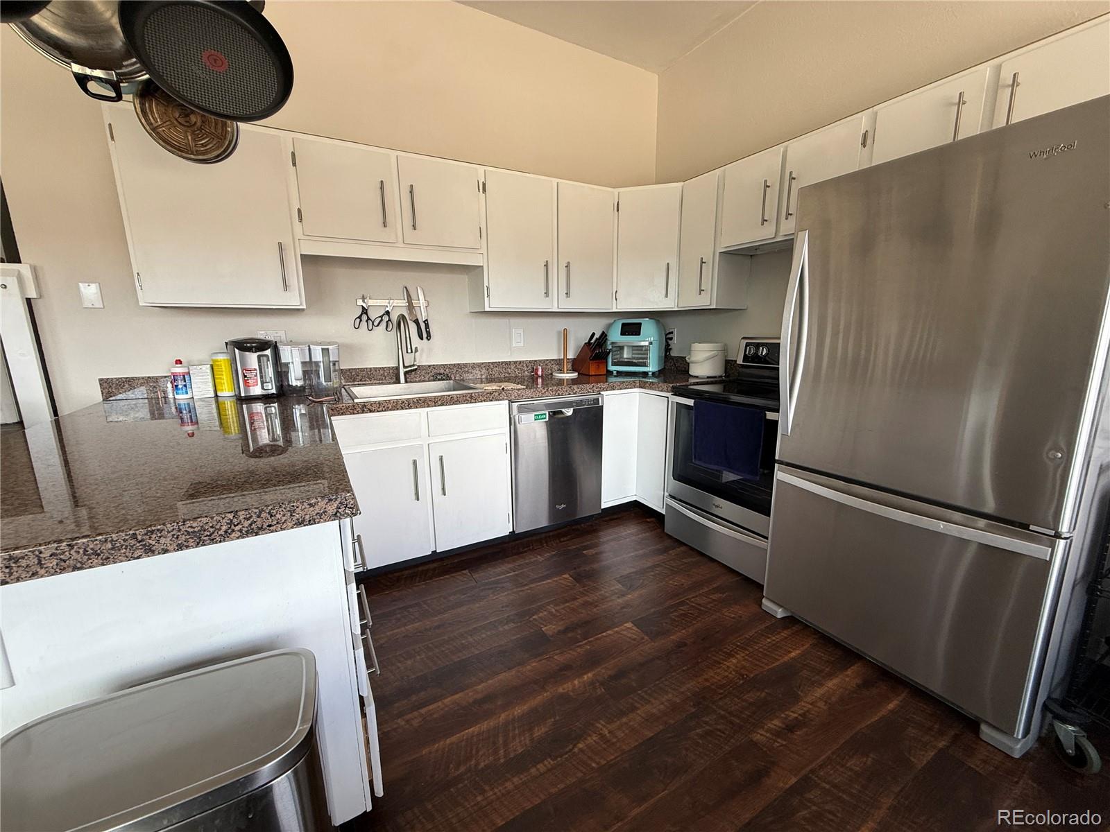 9876 Ryan Gulch Road, Unit 104 Silverthorne, CO 80498 - Photo 6 of 15 a kitchen with stainless steel appliances granite countertop a refrigerator a stove a sink and a granite counter tops