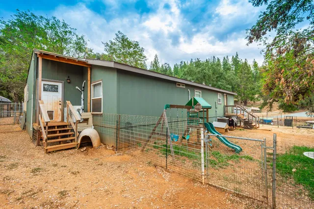 a kitchen with a refrigerator a stove top oven a sink dishwasher and a dining table with wooden floor