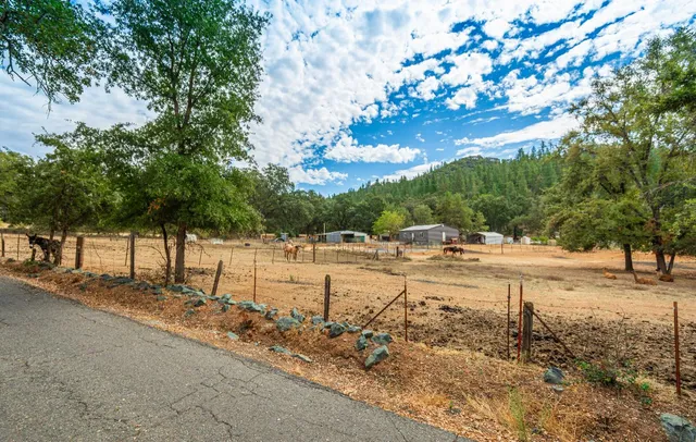 a view of a house with chairs and wooden fence
