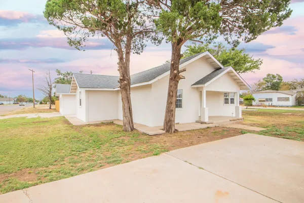 a white house that has a tree in front of it