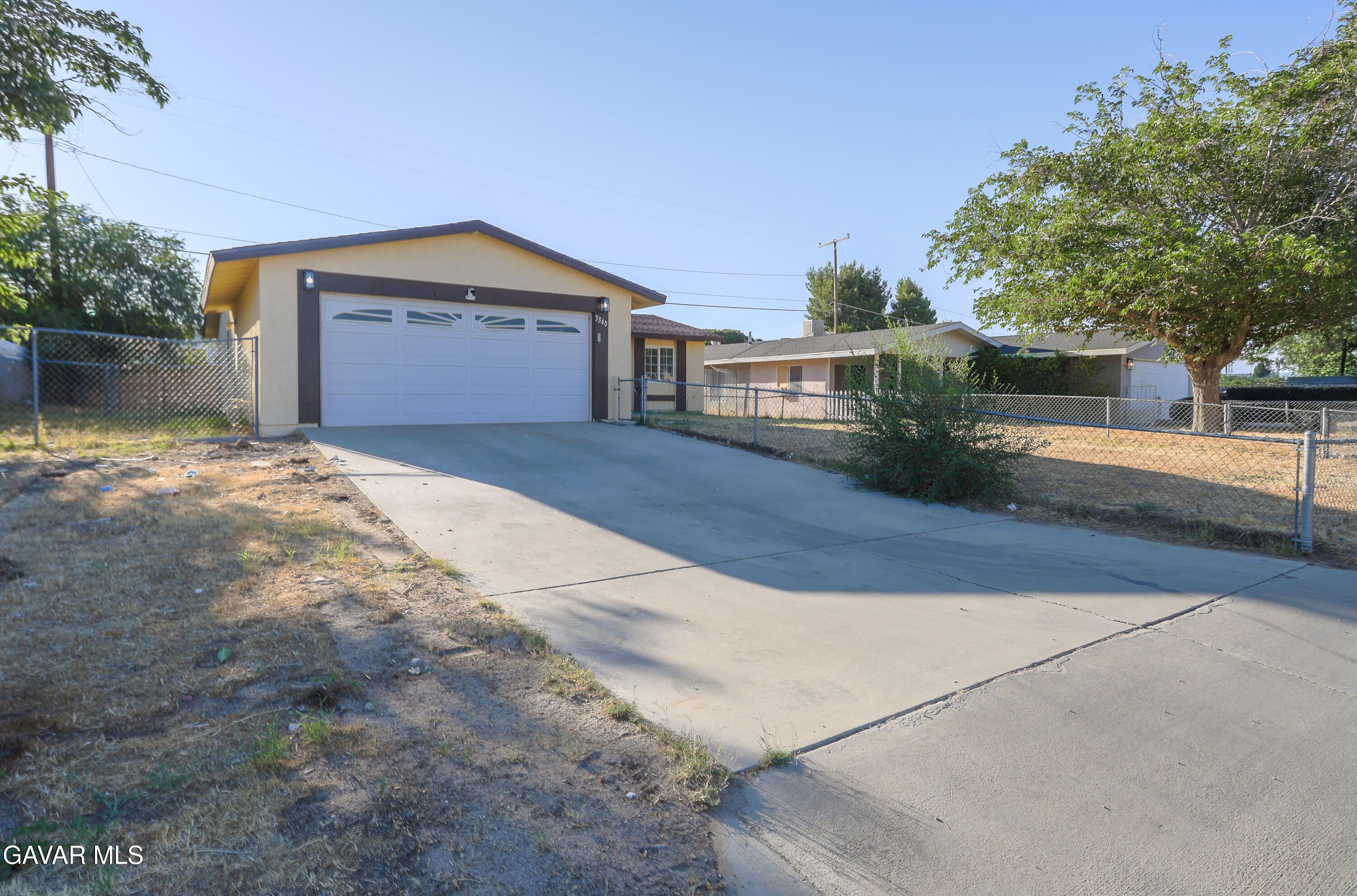 3340 West Roxbury Street Rosamond, CA 93560 - Photo 2 of 20 a front view of a house with a yard and garage