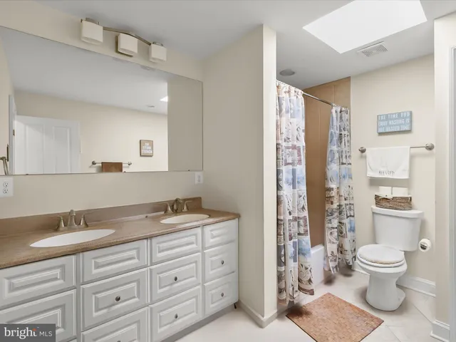 a spacious bathroom with a granite countertop sink a toilet and a shower