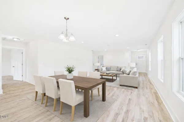 a view of a a dining room with furniture window and wooden floor