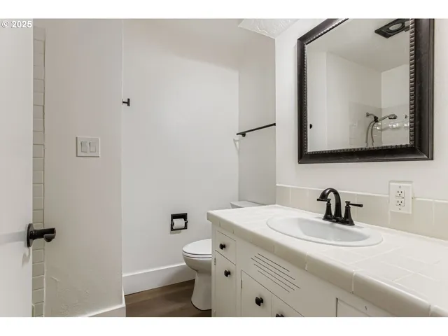 a bathroom with a toilet sink and mirror