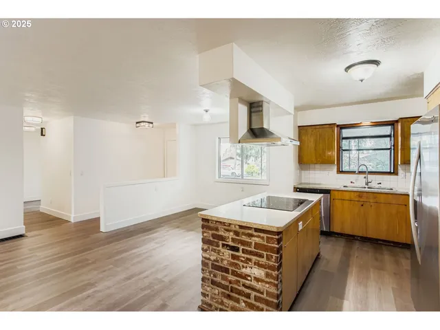 a kitchen with granite countertop a sink counter top space and stainless steel appliances