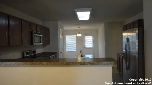 a kitchen with stainless steel appliances granite countertop a sink a stove and a refrigerator