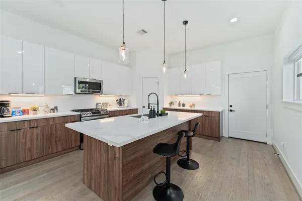 a kitchen with kitchen island a sink dining table and chairs