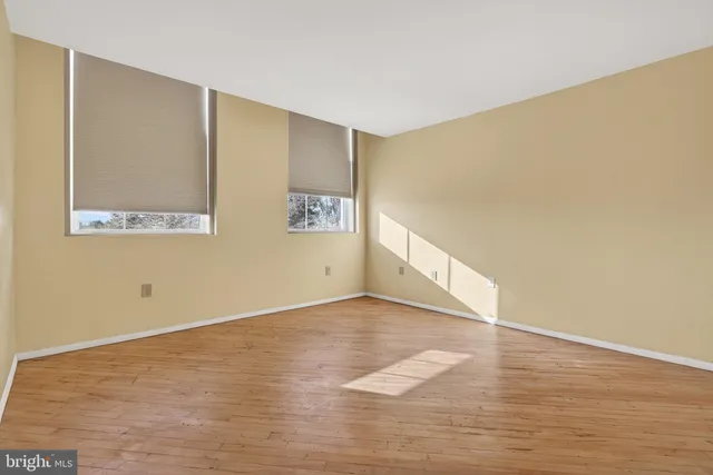 a view of an empty room with wooden floor
