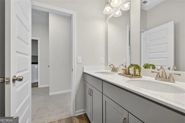 a bathroom with a sink double vanity granite tub shower and a mirror