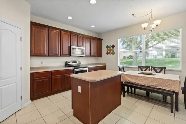 a kitchen with kitchen island granite countertop a stove a sink and a microwave