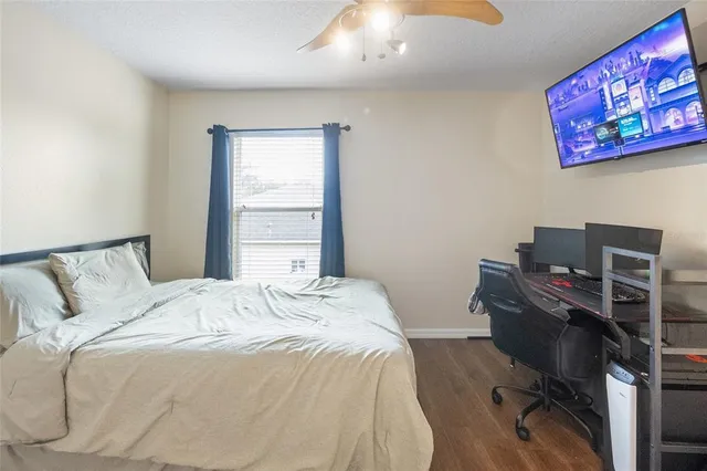 a bedroom with a bed and computer on the desk