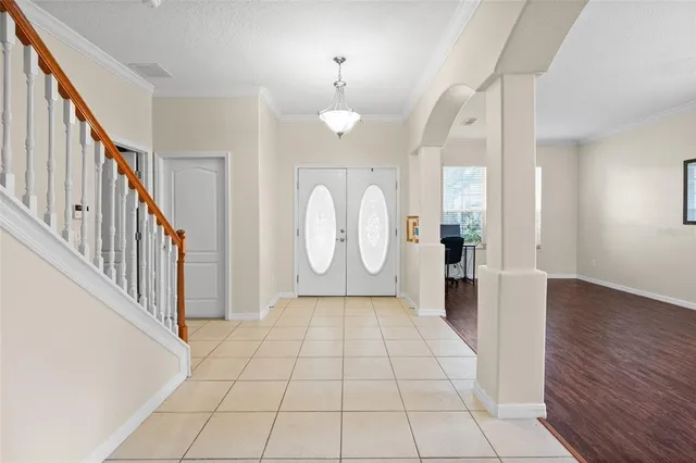 a view of a hallway with wooden floor and a chandelier