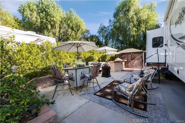 a view of a patio with chairs and table under an umbrella