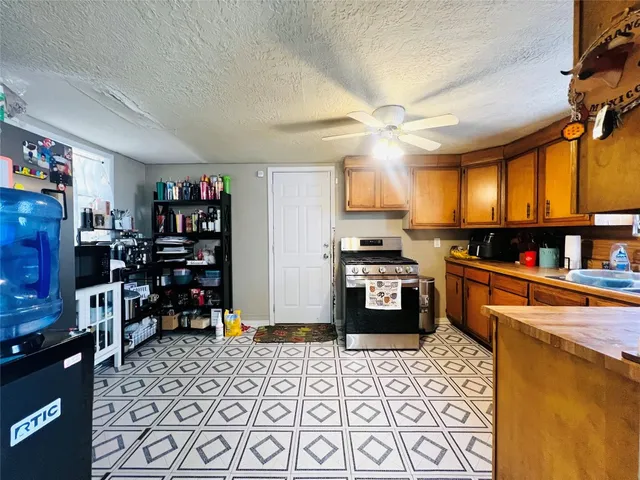 a kitchen with stainless steel appliances kitchen island granite countertop a refrigerator and a stove top oven