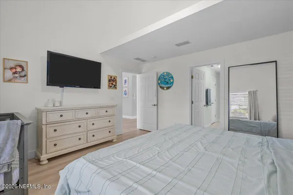 a view of a house with a large tree and wooden fence