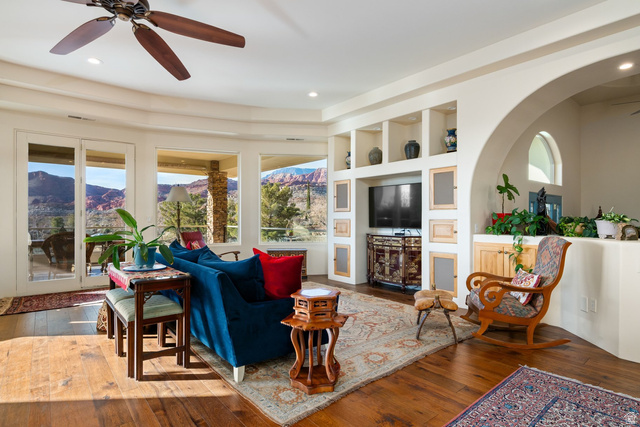 779 South Silver Road Leeds, UT 84746 - Photo 5 of 80 Living area with ceiling fan, built in features, wood-type flooring, and arched walkways