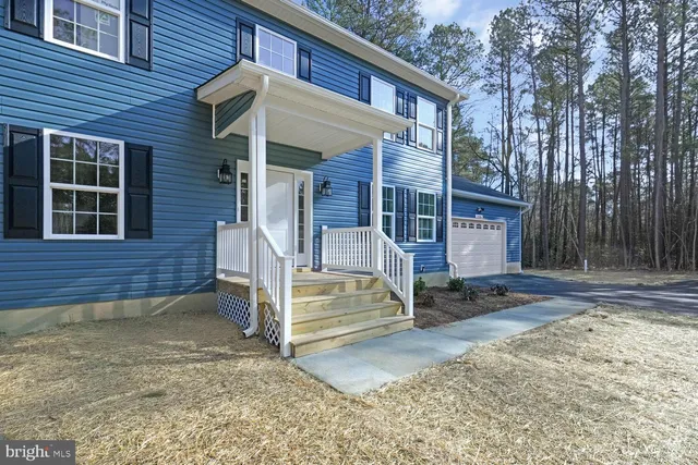 a view of a house with a yard and wooden fence