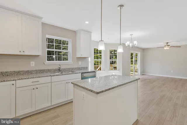 a kitchen with granite countertop a sink a center island and cabinets