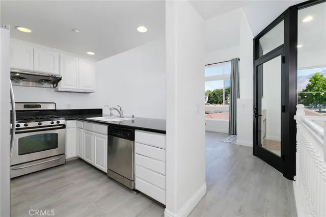 a kitchen with stainless steel appliances kitchen island granite countertop a stove and a refrigerator