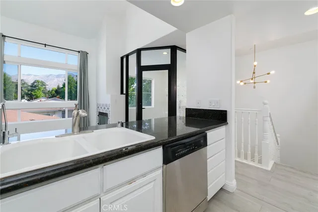 a kitchen with granite countertop a sink and a stove with wooden floor