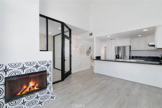 a view of kitchen with stainless steel appliances kitchen island wooden floor and living room