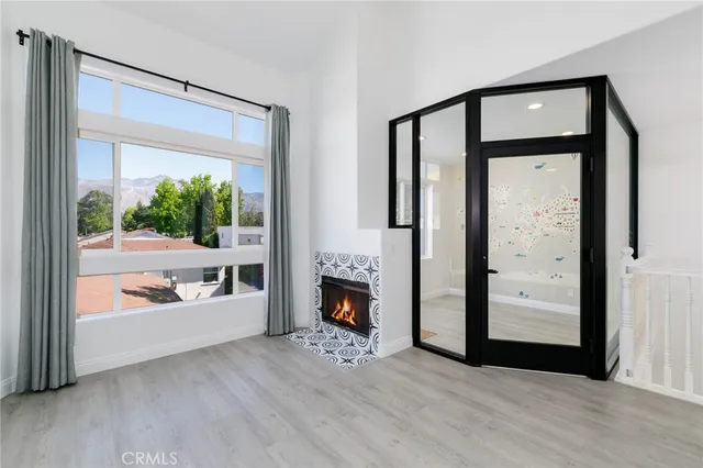 a view of an entryway with wooden floor windows and a fireplace