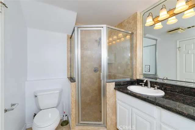 a bathroom with a granite countertop sink toilet and shower